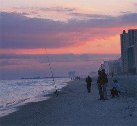 Myrtle Beach at Sunset. Myrtle Beach Condos and a dwindling number of beach-goers can be seen as the day ends.