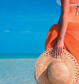 A woman at the beach looking out across the transparent water